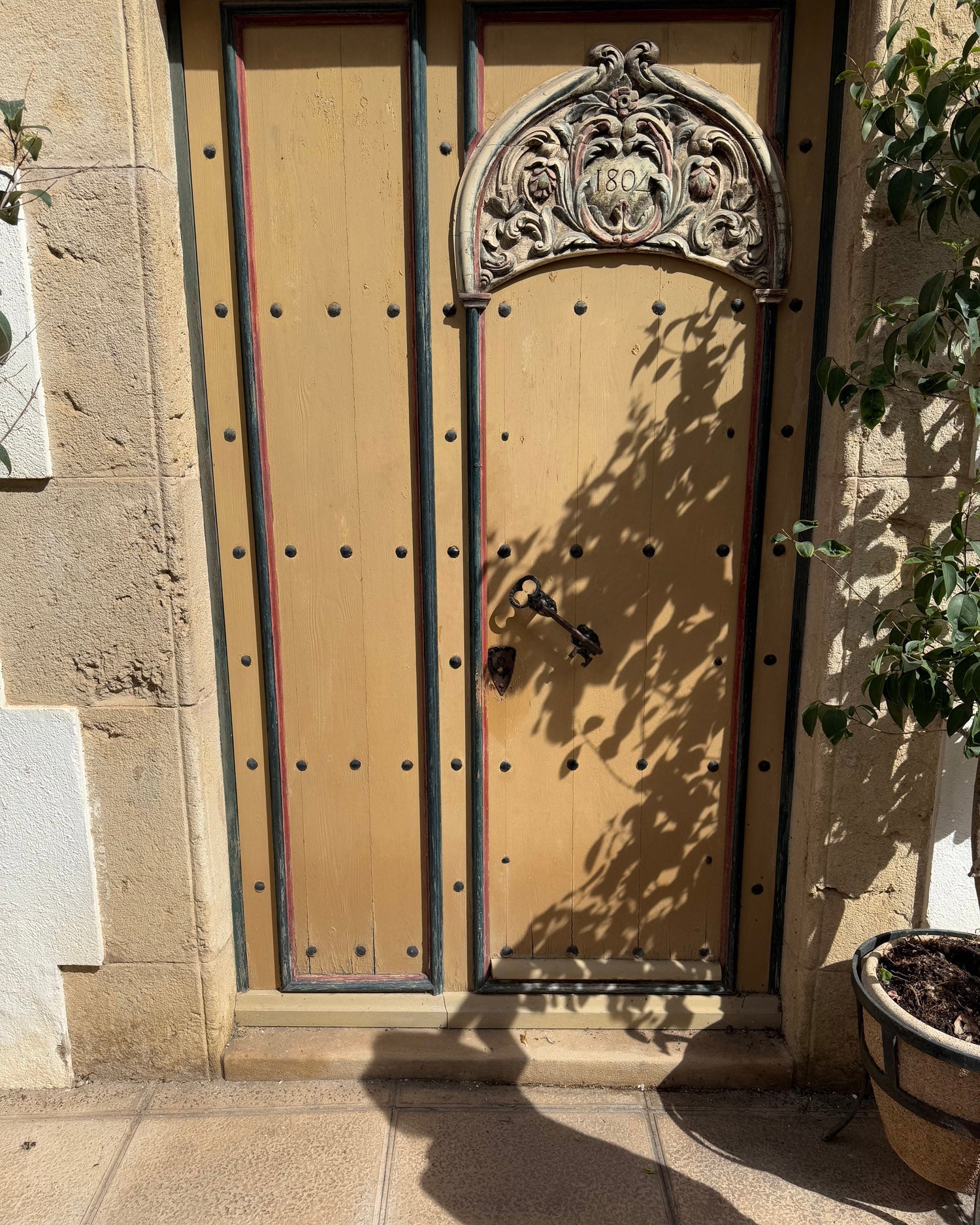 Decorative wooden door with intricate carvings on a stone building.